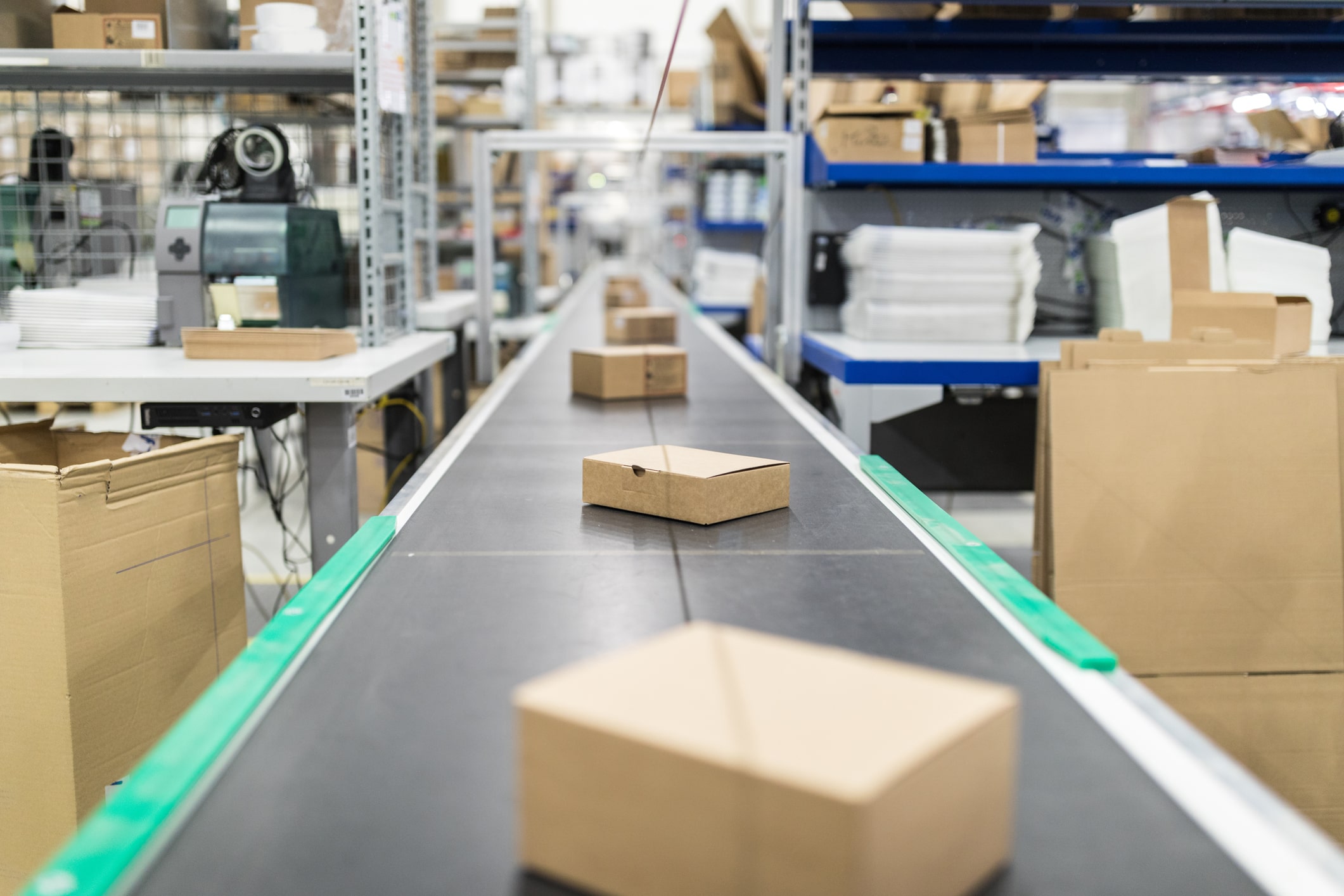 Cardboard boxes on conveyor belt at distribution warehouse